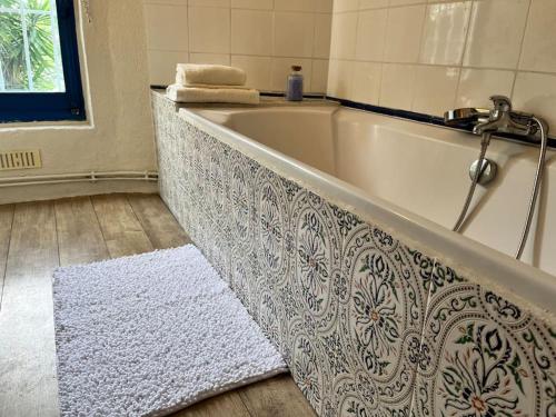 La salle de bains est pourvue d'une baignoire avec un tapis. dans l'établissement Moun Cantounet, authentique baraquette avec vue imprenable, à Sète