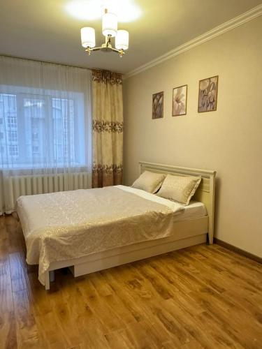 1 dormitorio con cama y ventana en Квартира, en Prigorodnyy