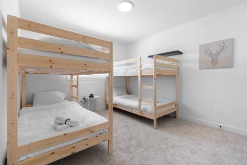 a bedroom with two bunk beds in a room at Family Home Retreat - 9 mins to WEM - Vintage Arcade-Ping Pong -Air Conditioning in Edmonton