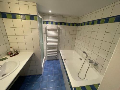 ein Badezimmer mit einer Badewanne und einem Waschbecken in der Unterkunft House & garden near Paris Arena in Vanves