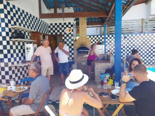 a group of people sitting at tables in a restaurant at Pousada do caju in Serra