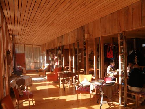 a living room with wooden floors and chairs and a person at La Baita Conguillio in Conguillio