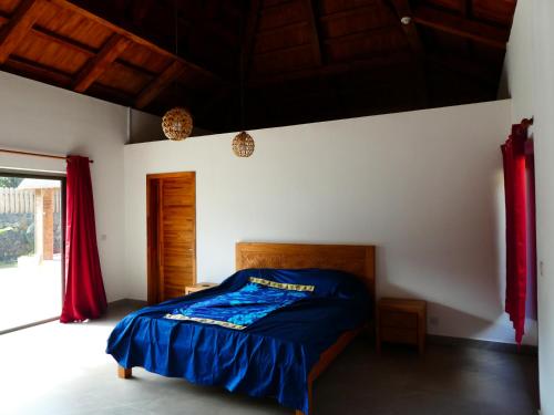 um quarto com uma cama com lençóis azuis e uma janela em VILLA LE DAUPHIN DU LAGON BLEU - PEREYBERE - GRAND BAIE em Grand Baie