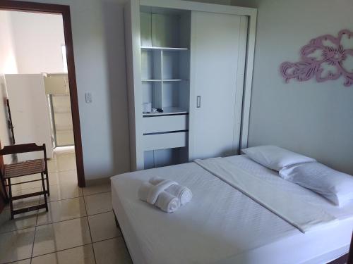 een slaapkamer met een bed met een handdoek erop bij Pousada do caju in Serra