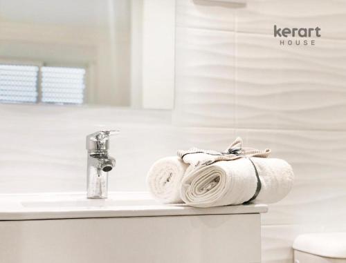 - une pile de serviettes assises sur un lavabo dans la salle de bains dans l'établissement Kerart Lima, à Armação de Pêra