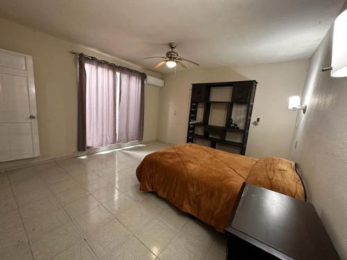 - une chambre avec un lit et un ventilateur de plafond dans l'établissement Casa cómoda y bonita, à Monterrey