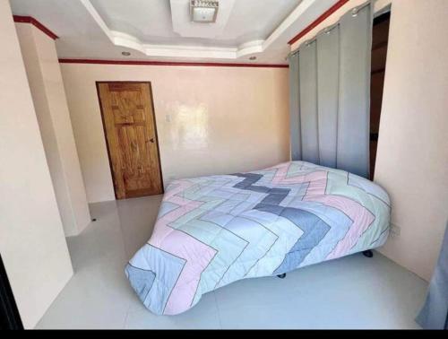 a bedroom with a bed in a room with a door at Casa Rosita Beach Front House in Surigao