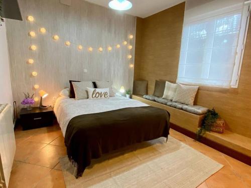 - une chambre avec un grand lit et un canapé dans l'établissement La Casuca del Postillo (Bajo con jardín y piscina), à Pontejos