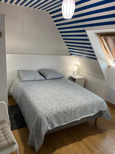 a bedroom with a bed with a blue and white striped ceiling at Chambre privée 1-2 coatodon in Guipavas