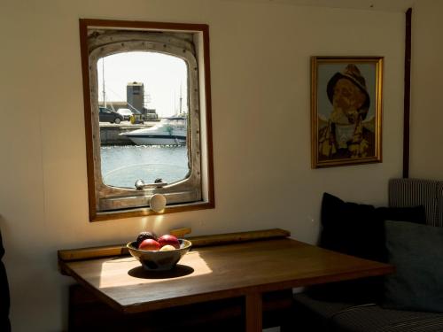 a bowl of apples on a wooden table in front of a mirror at Unique Boat Accomodation - Bornholm - Fjælstavn in Hasle