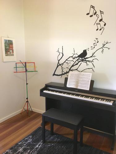 a piano with a bird on a branch with musical notes at Cottage with Piano, Books & Games in the Hunter in Singleton