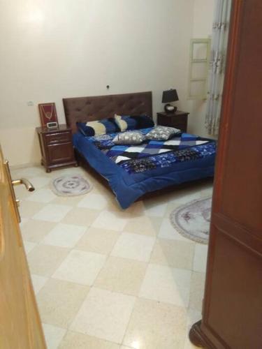 a bedroom with two beds with blue sheets and pillows at bienvenue agreable et chaleureuse in Biskra