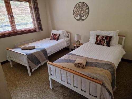a bedroom with two beds and a window at Wilmar Lodge in Arrochar