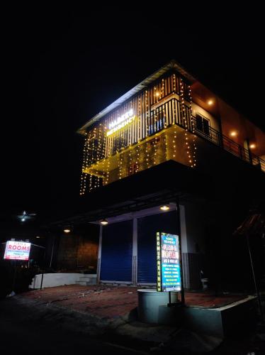a building with a sign on the side of it at night at Habees Residency in Chillithodu