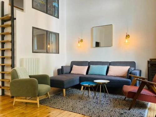 un salon avec un canapé bleu et des chaises dans l'établissement Appt de charme T3 50m2 hypercentre Cauterets, à Cauterets