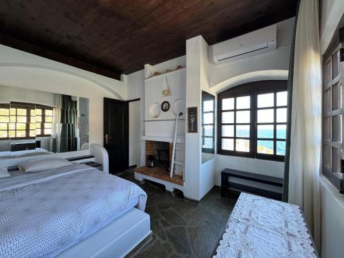 Hersonissos Andros في غافريون: غرفة نوم بسرير كبير ومدفأة