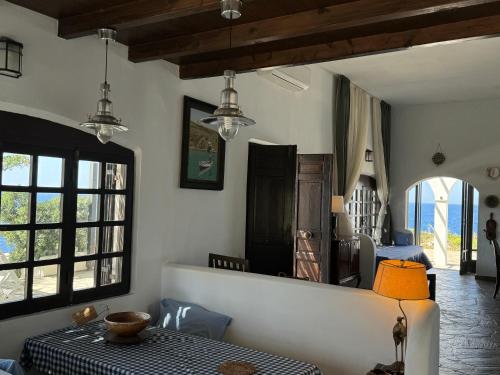 a living room with a table and some windows at Hersonissos Andros in Gavrion