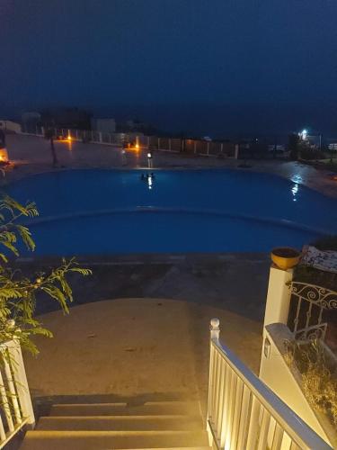 a view of a swimming pool at night at résidence les meridiennes tiguert in Agadir