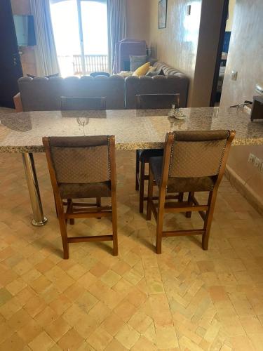 two chairs and a table in a living room at résidence les meridiennes tiguert in Agadir
