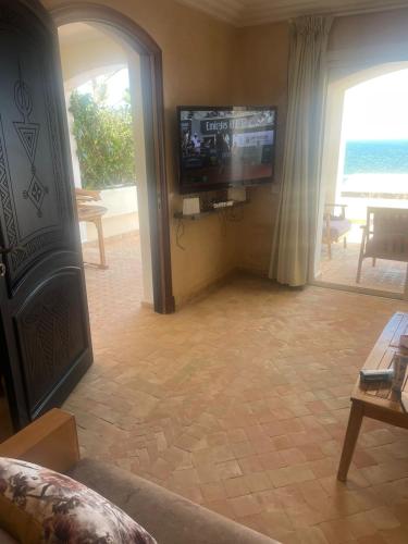 a living room with a flat screen tv and a couch at résidence les meridiennes tiguert in Agadir