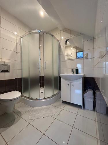 W łazience znajduje się prysznic, toaleta i umywalka. w obiekcie Mazurek Pokoje do wynajęcia w mieście Zełwągi