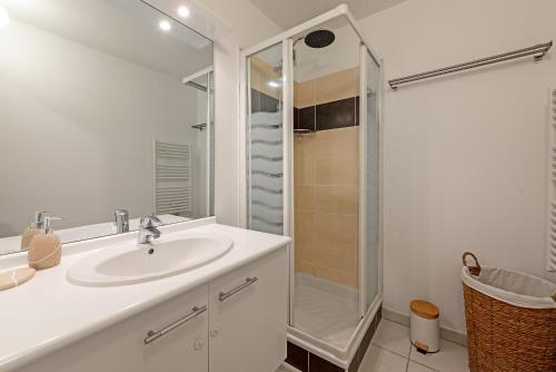 une salle de bain blanche avec un lavabo et une douche dans l'établissement Le Surf : Triplex (T4) parking, rooftop et clim, à Toulouse