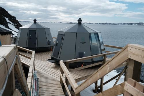 Deux dômes sur un quai à côté de l'eau dans l'établissement Aurora Hut by InukTravel, à Nuuk