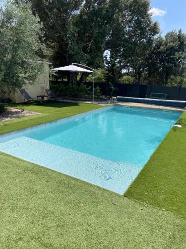 une grande piscine bleue dans une cour dans l'établissement Séjour détente et bien être avec SPA au gîte l Olipin, à Aubais