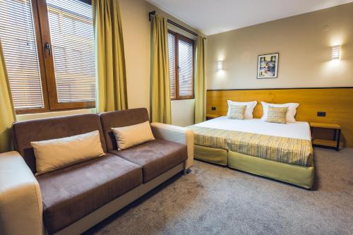 Habitación de hotel con sofá y cama en Hotel Albatros New Town, en Sozopol