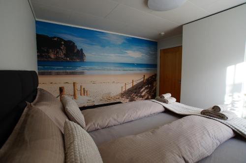 a bedroom with a large painting of a beach at Cozy room in a house with a garden on the island of Askøy, near Bergen in Askøy