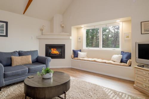 a living room with a couch and a fireplace at Arch Cape Inn and Retreat in Arch Cape