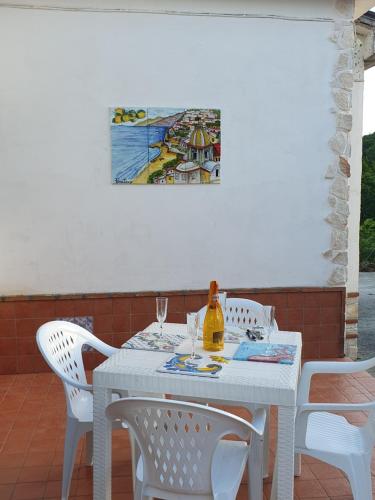 een witte tafel met stoelen en een schilderij aan de muur bij Masseria Marotta in Santa Paolina