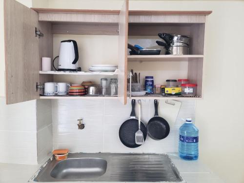- un comptoir de cuisine avec évier et ustensiles dans l'établissement Sunset suite, à Meru