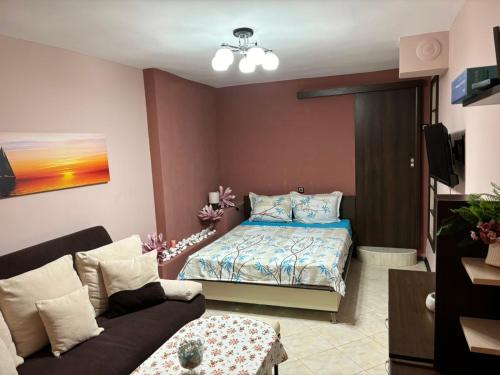 a living room with a bed and a couch at Партерно Студио in Ahtopol