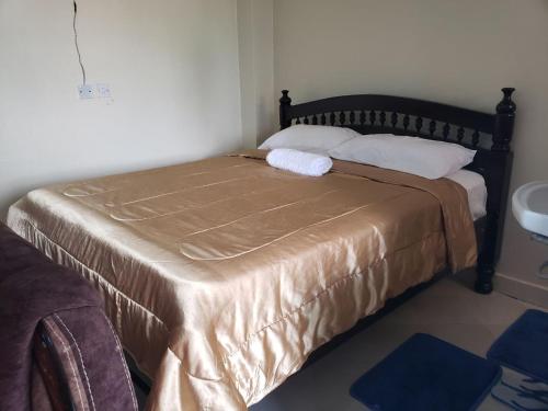 Bett in einem kleinen Zimmer mit Tagesdecke in der Unterkunft Sunset suite in Meru