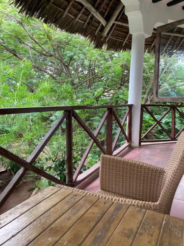 a wicker chair sitting on top of a wooden deck at PASA LODGE ZANZIBAR in Nungwi