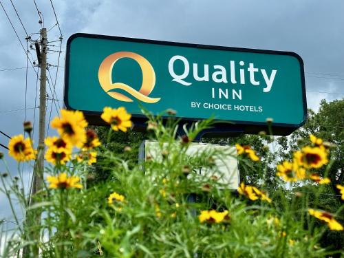 ein Zeichen für ein hochwertiges Gasthaus neben einem Sonnenblumenfeld in der Unterkunft Quality Inn At Eglin AFB in Niceville