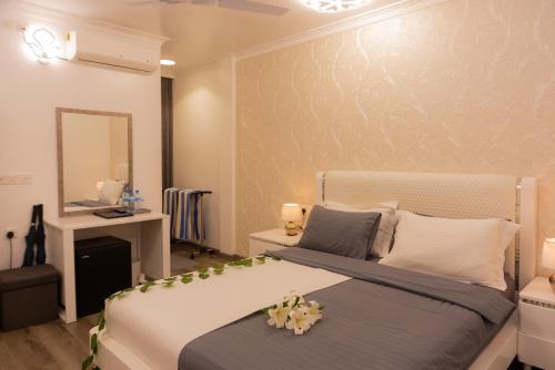 1 dormitorio con cama y escritorio con espejo en SIS Tourist Villa, Mathiveri, Maldives, en Mathiveri