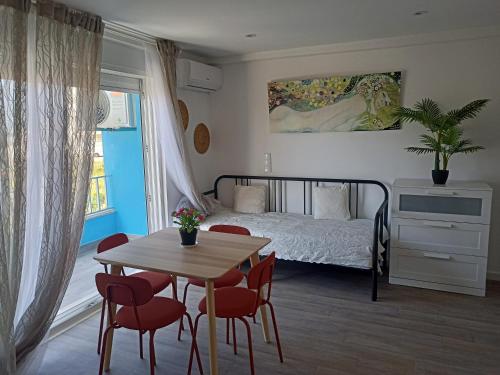 a bedroom with a bed and a table and chairs at Mata Beach Caparica in Costa da Caparica