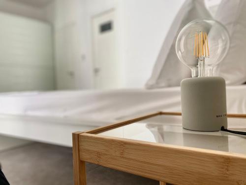 a glass table with a lamp on it next to a bed at Central, spacious and bright 2-bedroom apartment By Estio Comfort Living in Heraklio