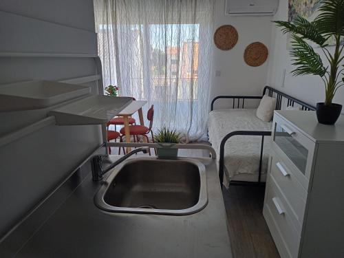 a kitchen with a sink and a bedroom with a bed at Mata Beach Caparica in Costa da Caparica