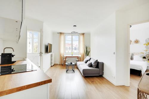 Il comprend un salon blanc avec un canapé et une cuisine. dans l'établissement Modern and new flat - Paris 12th - near le Marais and Bois de Vincennes, à Paris