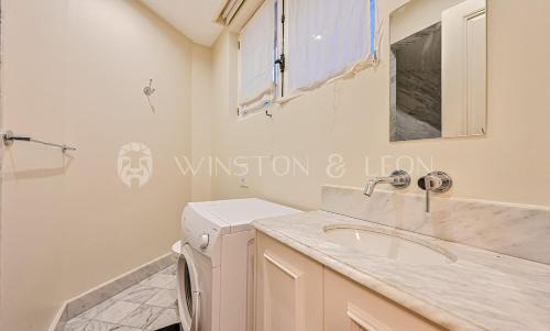 une salle de bain avec un lavabo et une machine à laver dans l'établissement Appartement Paris 7e Invalides Tour Eiffel, à Paris