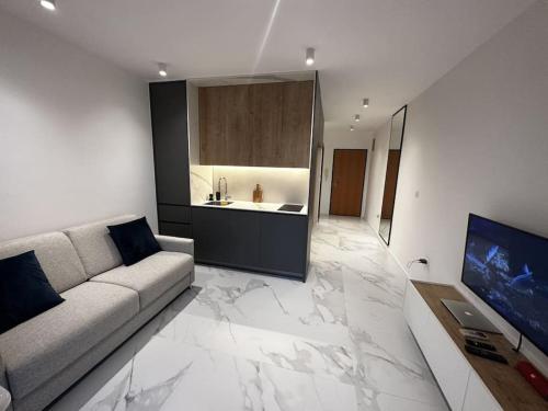 a living room with a couch and a kitchen at Serenity Seaview Suite Przno in Pržno