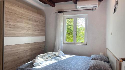 een slaapkamer met een bed en een raam bij Apartment Mornar in Kaštela