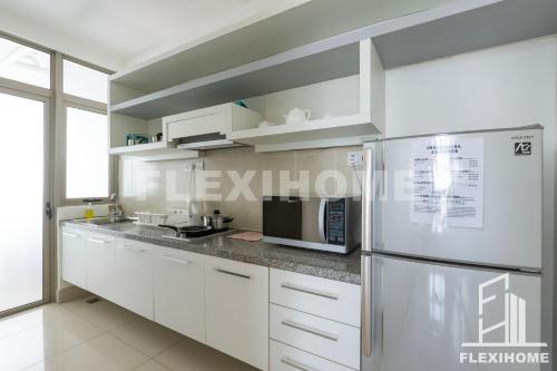 a kitchen with white cabinets and a stainless steel refrigerator at 9am-5pm, SAME DAY CHECK IN AND CHECK OUT, Work From Home, Shaftsbury-Cyberjaya, Comfy Home by Flexihome-MY in Cyberjaya