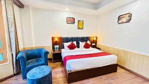 una camera d'albergo con letto e sedia di Ocean Inn a Manāli
