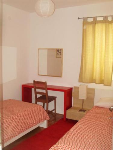 a bedroom with two beds and a desk and a chair at Mazuran2 in Hvar
