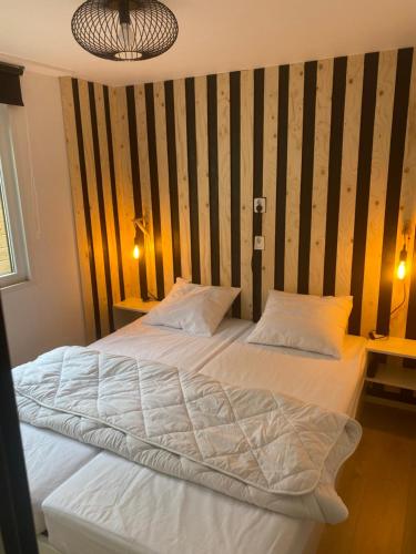a bedroom with a large bed with two pillows at Sfeervol chalet Hoenderloo, de Veluwe in Hoenderloo
