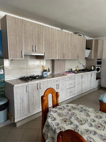 una cocina con armarios de madera, una mesa, una mesa y un mantel en Мотель Ріта, en Beregovo